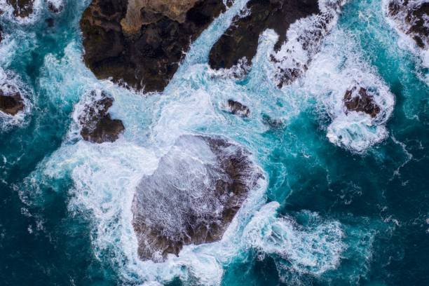 istock Aerial view of waves crashing on rocks 1437447281