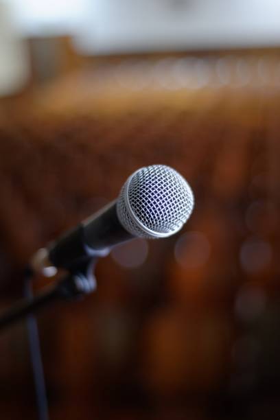 istock Vertical image of a microphone against a blurry background 1437447619