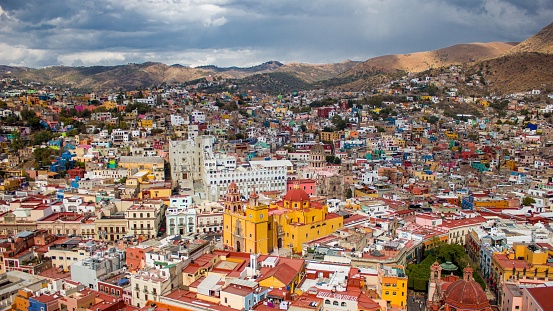An aerial shot of the beautiful Mexican Guanajuato city with colorful buildings surrounded by mountains