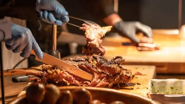 A person slicing the brisket on the table in Texas, USA