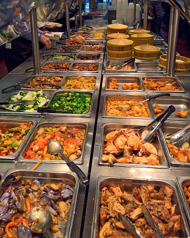 A vertical shot of a buffet with Chinese food and dim sum items