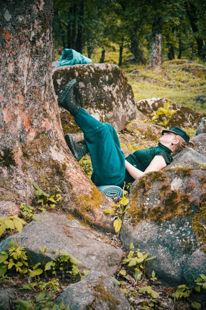 istock Lonely young female sleeping by a tree and next to rock formations 1437450676