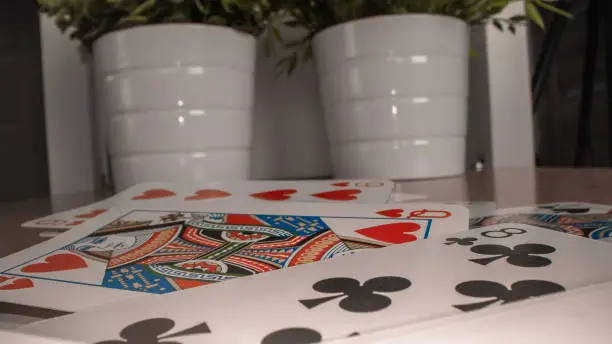A closeup of playing cards and ceramic pots with plants in the back