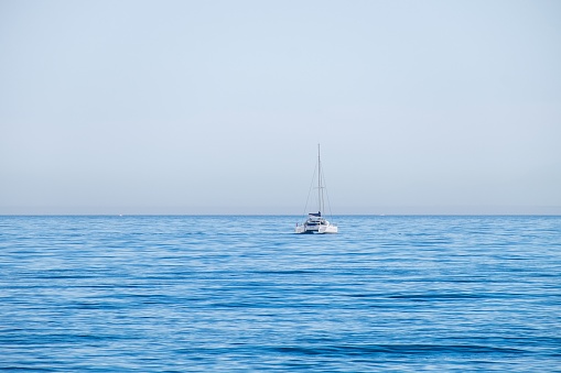 – June 06, 2022: Estepona, Malaga, Spain - June 06, 2022: A solitary catamaran sailing along the Costa del Sol in Malaga