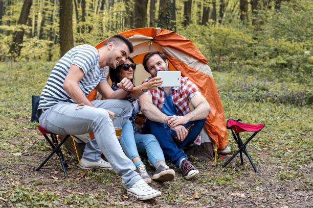 istock Young cheerful friends taking photo selfie while doing a picnic 1437454853