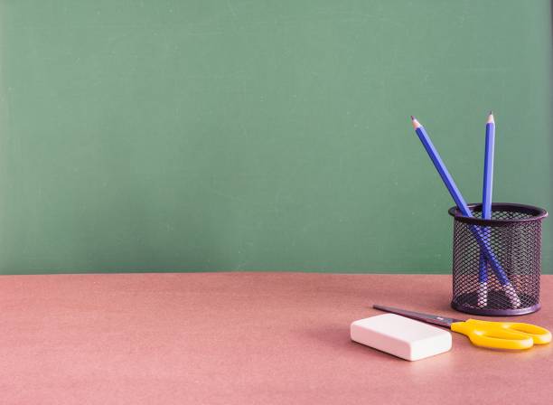 istock Green chalkboard with space for text behind the desk 1437455644