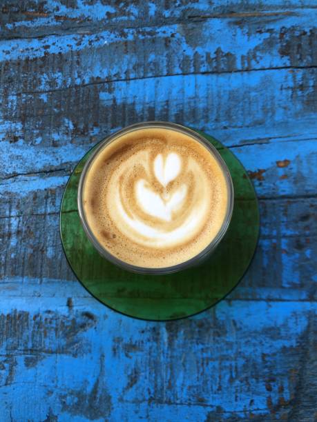 istock Vertical high angle shot of cappuccino on a blue wooden surface 1437456247