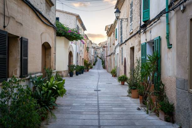 Path surrounded by aged buildings in Alcudia, Mallorca, Spain A path surrounded by aged buildings in Alcudia, Mallorca, Spain bay of alcudia stock pictures, royalty-free photos & images