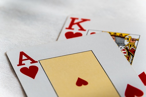 A royal flush poker hand with a pile of cash in background. A concept of a winning hand for poker or in other high stake pursuits.