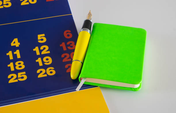 istock A green notepad on a blue paper calendar with colored paper numbers 1437458611