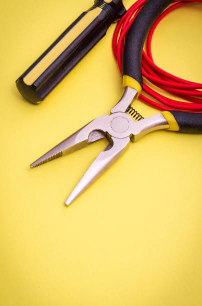 istock Electrician's tools and wire on yellow background for repairing energized systems or communications 1437458627