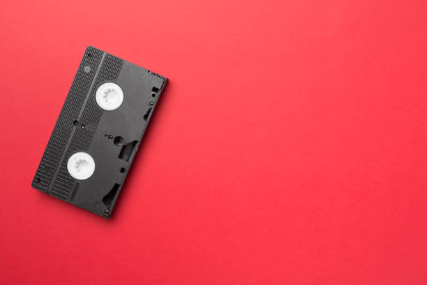 istock Old analog tape VHS cassette on color background, top view 1437459964