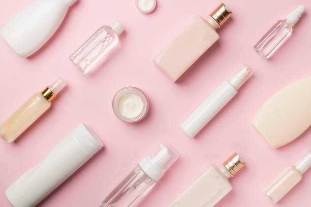 istock Different cosmetic bottles and container on color background, top view 1437460688