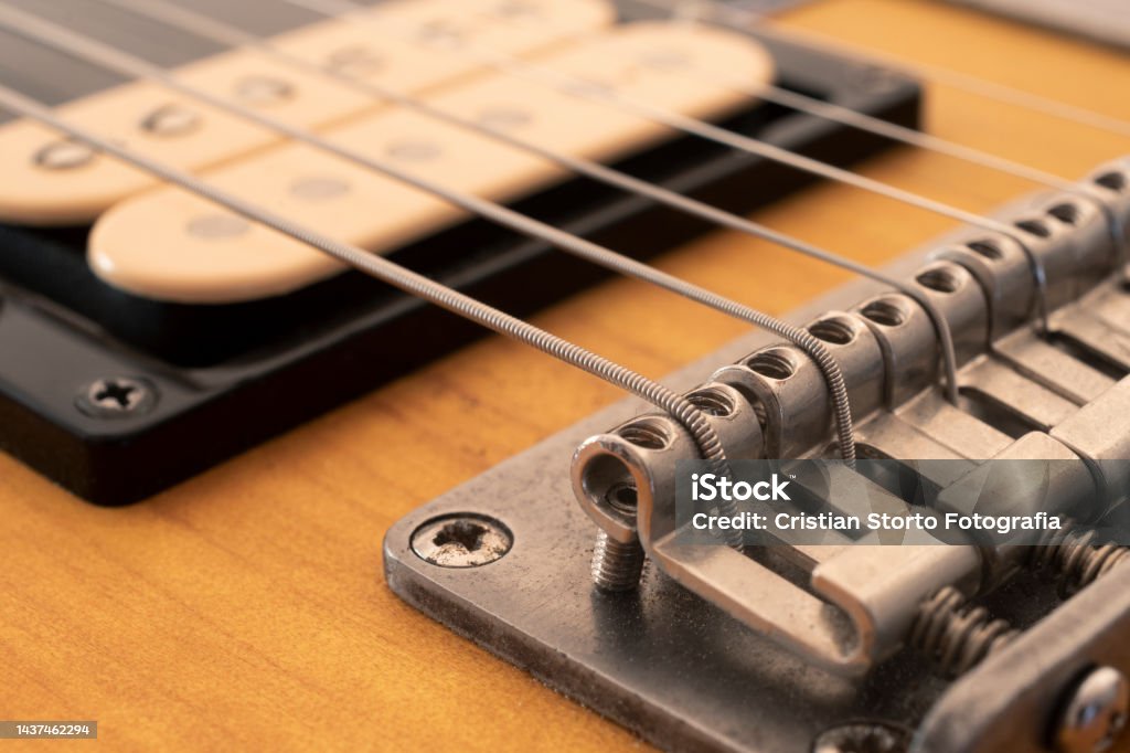 Detail of the bridge saddles of an electric guitar with selective focus Backgrounds Stock Photo