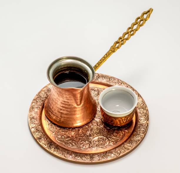 Closeup of coffee in a cezve on the tray with a cup isolated on a white background A closeup of coffee in a cezve on the tray with a cup isolated on a white background turkish coffee pot cezve stock pictures, royalty-free photos & images