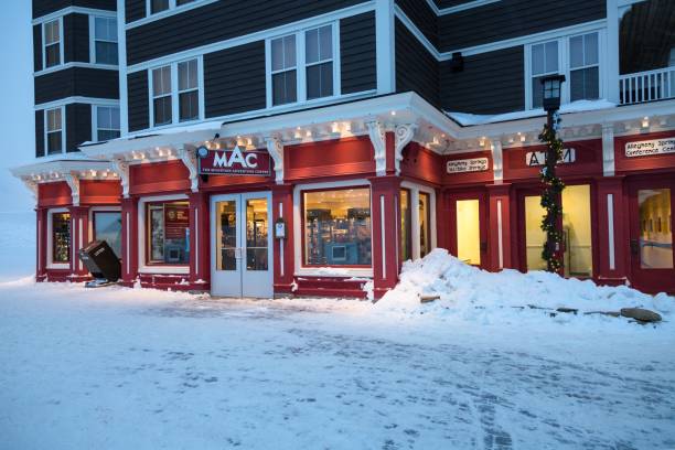 Snowshoe Mountain Adventure Center Snowshoe, WV, United States – February 27, 2015: Night time image of the Snowshoe Mountain Resort Adventure Center Building along with several other Businesses located at Snowshoe Resort, WV. snowshoeing snow shoe red stock pictures, royalty-free photos & images