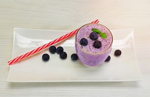 An overhead shot of a refreshing glass of blueberry milkshake