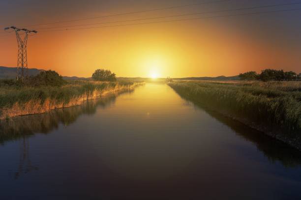 istock River with electric lines during an orange sunset 1437480981