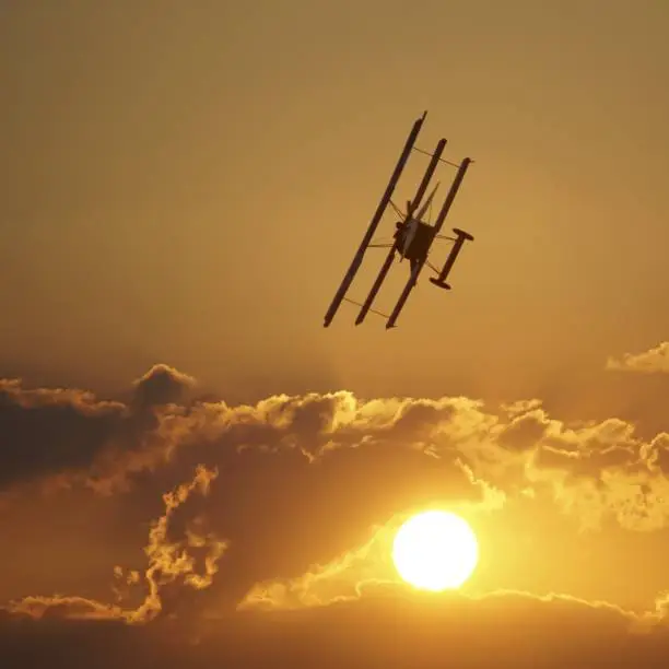 A Fokker DR I plane in the sky during the orange sunset
