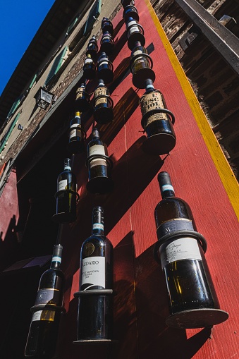 Castiglion del Lago, Italy – April 10, 2022: A low angle shot of outdoor wine bottles exterior building on red background