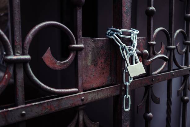 istock Lock attached to a chain keeping the metal gates closed 1437481609