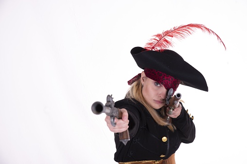 A female in a pirate costume pointing with two pistols