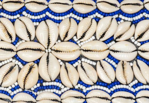 крупный план нанизанных бело-синих струн и раковин каури, образующих уз�ор - cowrie shell стоковые фото и изображения