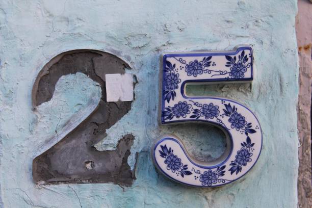 istock Old house number on the blue wall twenty five 1437482601