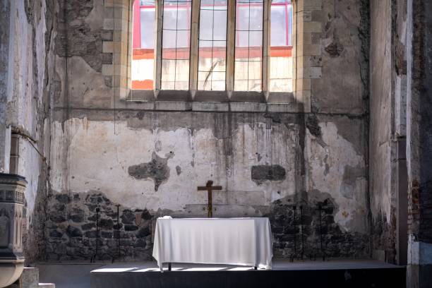 istock Abandoned church with a small table and cross inside the building 1437483717