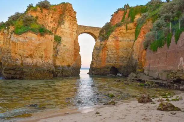 The beautiful arch between the giant cliffs in Praia de Batata, Portugal
