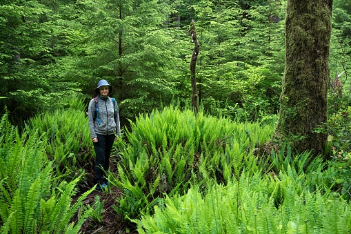A Caucasian hiker woman posing in lush greenery at Carmanah Walbran Provincial Park