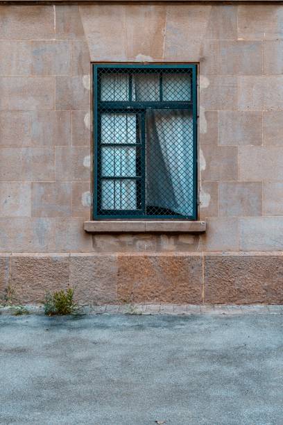 istock Facade of an old house, Iron window with white curtains flapping in the wind. 1437485443