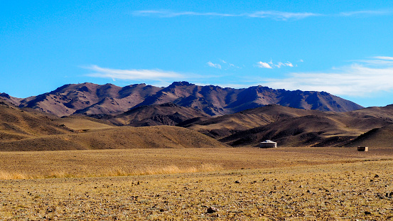 Ella en el campo mongol con las montañas del desierto de Gobi en el fondo photo