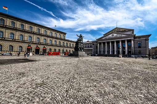 Front View Of Bavarian State Opera In Munich, Germany. Max Joseph Denkmal - statue made by Johann Baptist Stiglmaier in 1835.