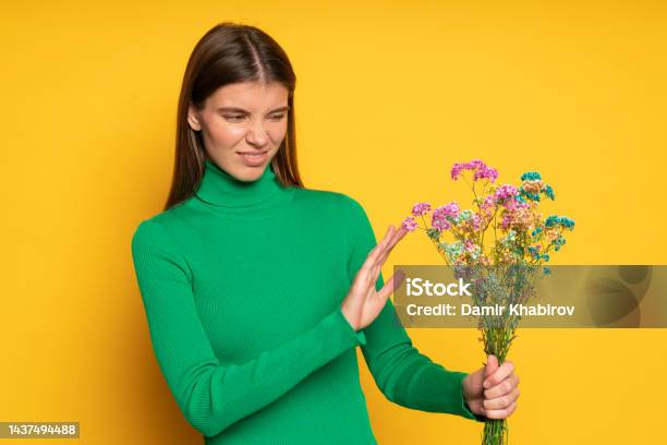 Allergic Woman Holding Bouquet Of Flowers Doing No Gesture With Ugh Facial Expression Stock Photo - Download Image Now