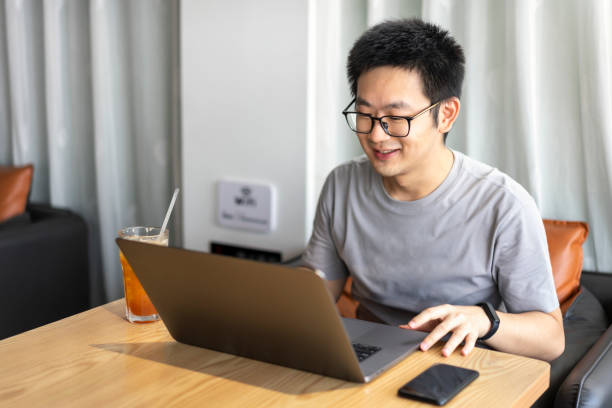 istock Asian male freelancer using a laptop in cafe 1437496232