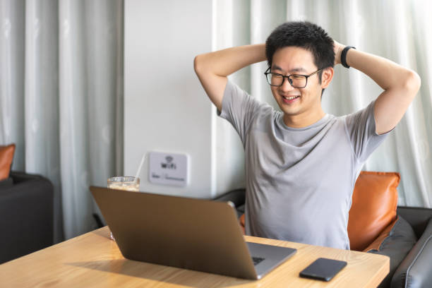 istock Asian male freelancer using a laptop in cafe 1437496254