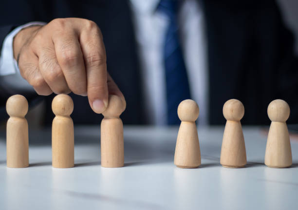 istock Executives hand in hand with wooden dolls. (organization management concept) 1437497854