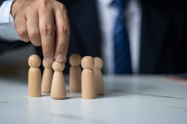 istock Executives hand in hand with wooden dolls. (organization management concept) 1437497855