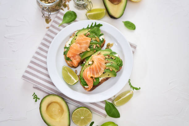 istock Freshly made Avocado, salmon and cream cheese toasts on a white ceramic plate 1437501252