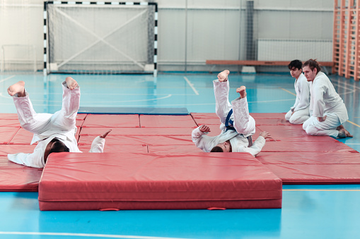 Backward Falls Practiced As Warmup Technique By Judokas In Dojo