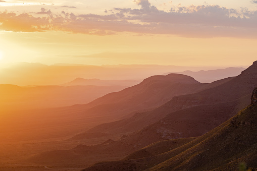 A golden sunset in the Tankwa Karoo National Park, South Africa. The photo is shot from the top of the Gannaga Pass, looking towards the Cederberg Mountains on the distant horizon.