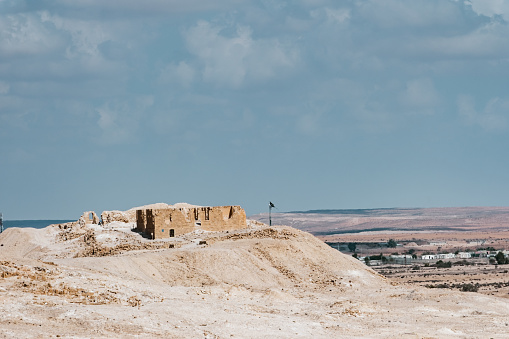 Ancient settlement ruins in Desert Landscape in Middle East. Surreal view of remote location during the day.