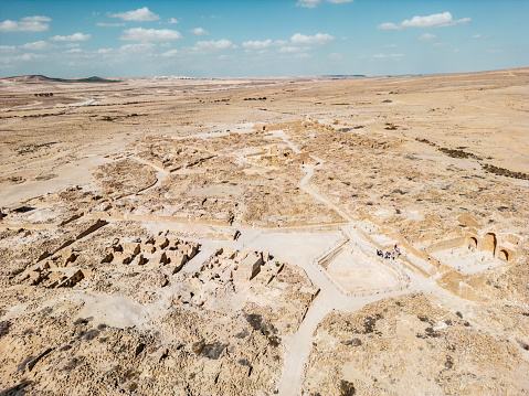 Ancient settlement ruins in Desert Landscape in Middle East. Surreal view of remote location during the day.