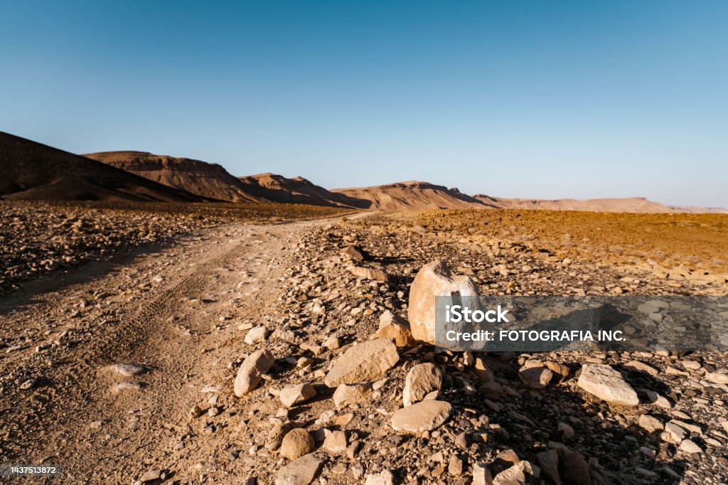 Road marking in Desert Landscape in Middle East Desert Landscape in Middle East. Surreal view of remote location during the day. Dirt Road Stock Photo
