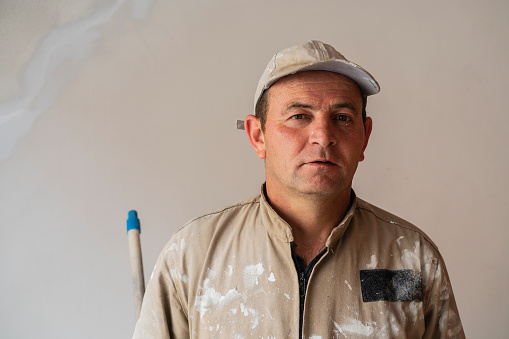 Portrait of a construction worker looking at the camera while having his face covered in paint