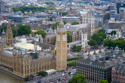 Aerial view of Westminster Palace, Westminster Abbey, Westminster Bridge and Thames River on a cloudy summer day. Photo taken August 3rd, 2022, London, England.
