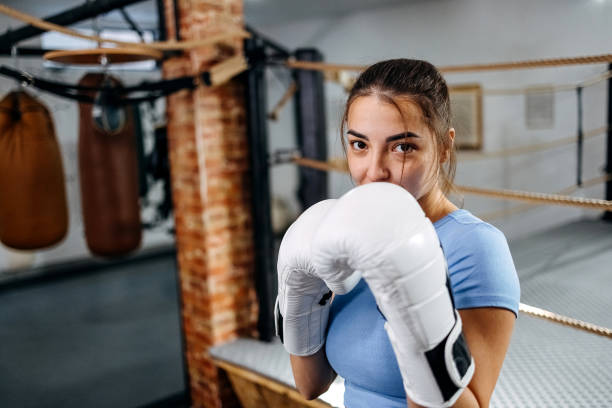 Portrait of a female boxer Portrait of a young woman practicing boxing fighting stance stock pictures, royalty-free photos & images