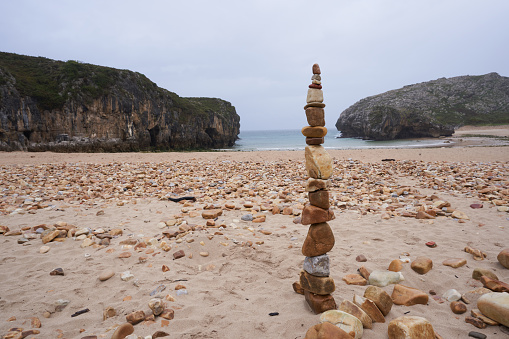 Stones stacked one on top of the other in the sand of a beautiful beach in the north of Spain. Representation of inner balance with copy space.
