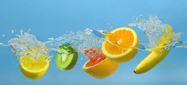 istock Fruits mix splashing into clear water on blue background 1437522750